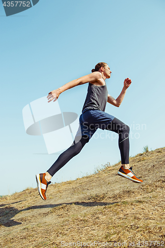 Image of Running sport. Man runner sprinting outdoor in scenic nature. Fit muscular male athlete training trail running for marathon run.