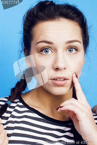 Image of young pretty woman fooling around on blue background close up smiling