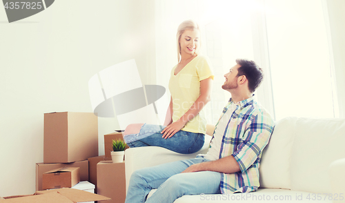 Image of happy couple with big cardboard boxes at new home