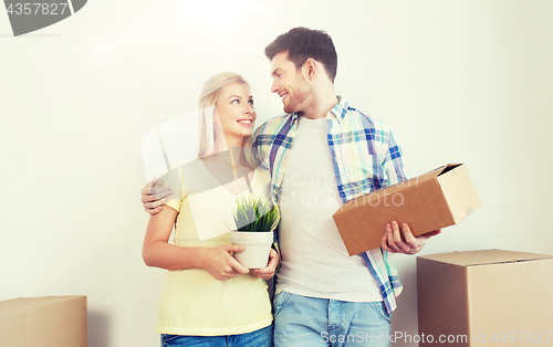 Image of smiling couple with big boxes moving to new home