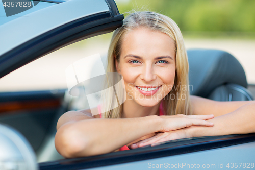 Image of happy young woman in convertible car