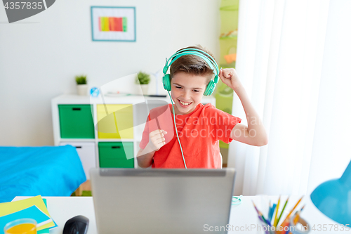 Image of boy in headphones playing video game on laptop