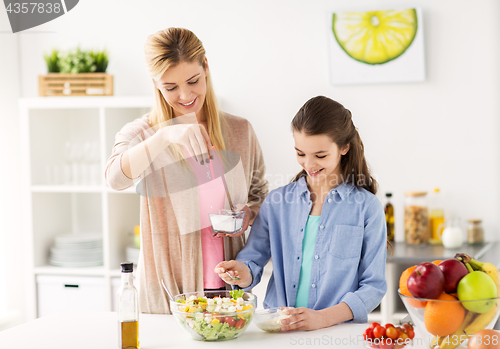 Image of happy family cooking salad at home kitchen