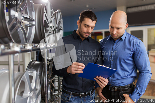 Image of customer and salesman at car service or auto store