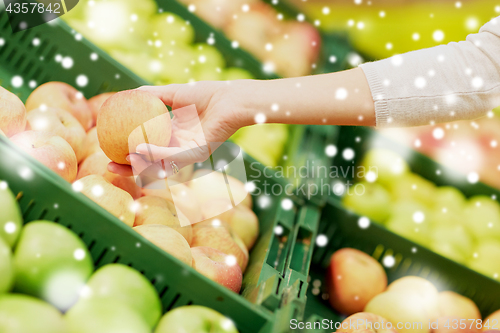 Image of hand with apples at grocery store