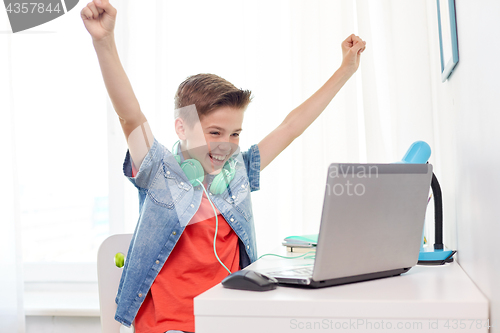 Image of boy with headphones playing video game on laptop