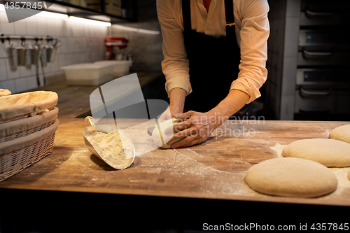 Image of baker portioning dough with bench cutter at bakery