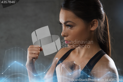 Image of woman holding fists and fighting in gym