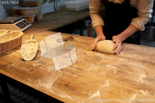 Image of baker making bread dough at bakery kitchen