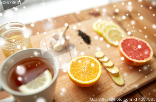 Image of ginger tea with honey, citrus and garlic on wood