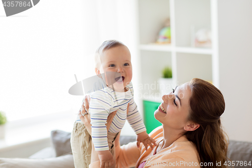 Image of happy young mother with little baby at home