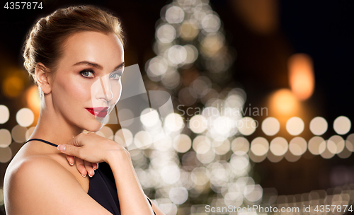 Image of beautiful woman over christmas tree lights