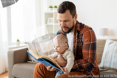 Image of happy father and little baby boy with book at home