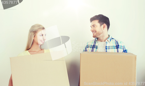 Image of smiling couple with big boxes moving to new home