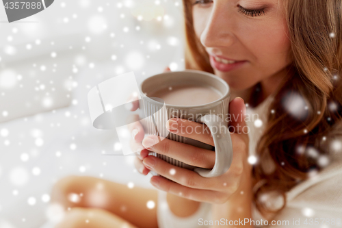 Image of close up of happy woman with cup of cocoa at home