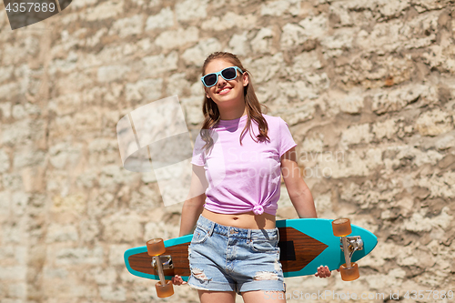 Image of happy teenage girl in shades with longboard