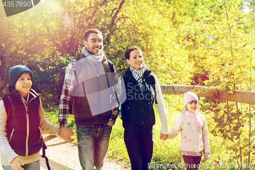 Image of happy family with backpacks hiking in woods