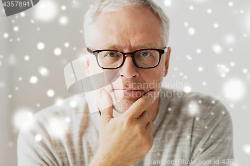 Image of close up of senior man in glasses thinking