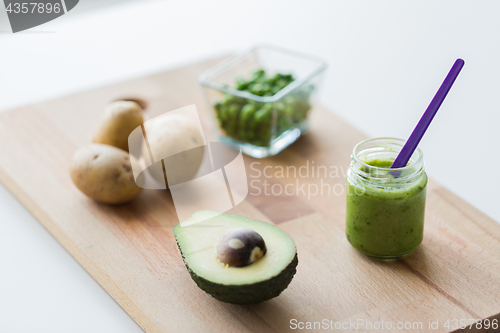 Image of jar with puree or baby food on wooden board