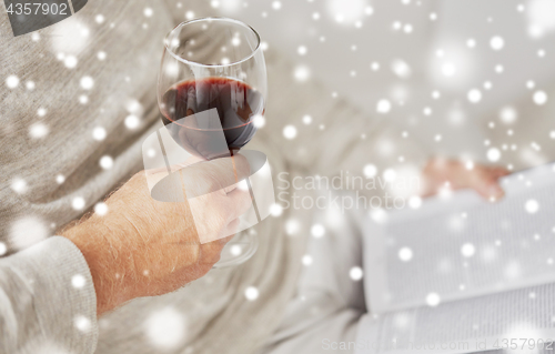 Image of close up of senior man with wine glass and book