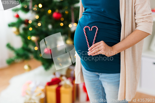 Image of close up of pregnant woman with heart at christmas