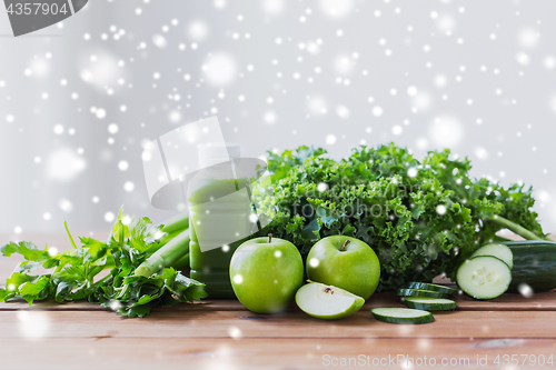 Image of close up of bottle with green juice and vegetables