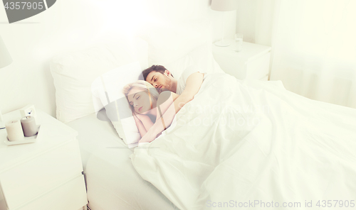 Image of happy couple sleeping in bed at home