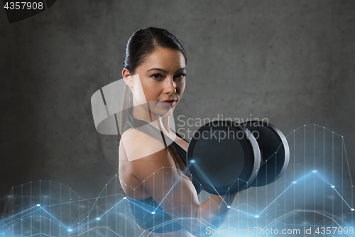 Image of young woman flexing muscles with dumbbells in gym