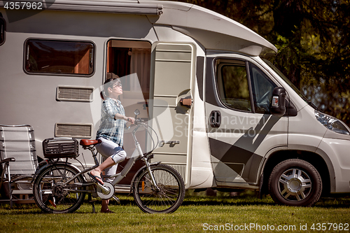 Image of Woman on electric bike resting at the campsite VR Caravan car Va