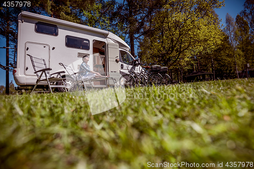 Image of Woman resting near motorhomes in nature. Family vacation travel,