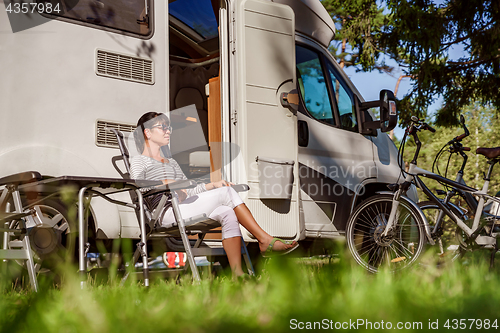 Image of Woman resting near motorhomes in nature. Family vacation travel,