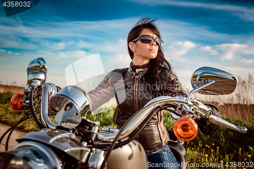 Image of Biker girl sitting on motorcycle