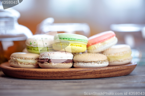 Image of Close-up of colorful macaron (macaroon) on the table with hot te