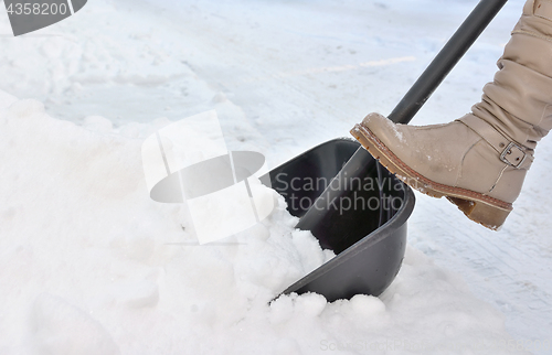 Image of Woman Shoveling snow on street