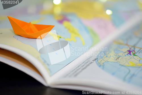 Image of Paper boat on a atlas book