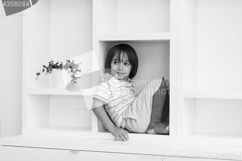 Image of young boy posing on a shelf