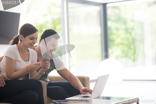 Image of happy young couple buying online