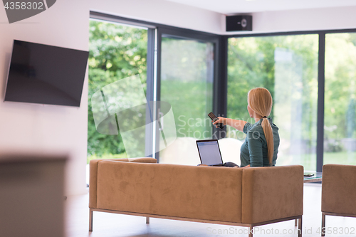 Image of Young woman using laptop at home