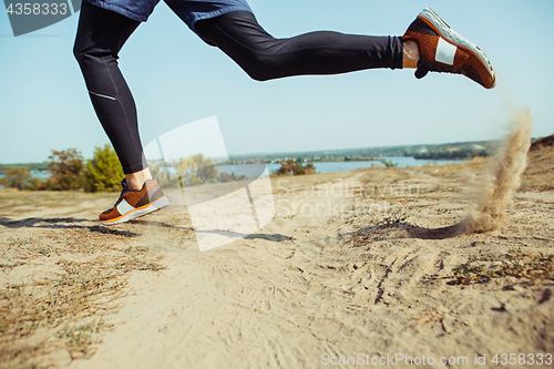 Image of Running sport. Man runner sprinting outdoor in scenic nature. Fit muscular male athlete training trail running for marathon run.