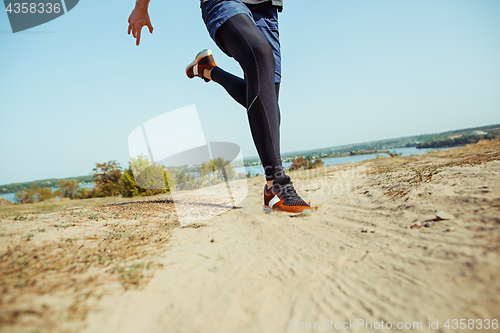 Image of Running sport. Man runner sprinting outdoor in scenic nature. Fit muscular male athlete training trail running for marathon run.