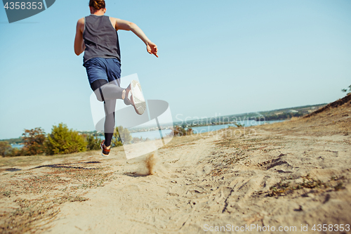 Image of Running sport. Man runner sprinting outdoor in scenic nature. Fit muscular male athlete training trail running for marathon run.