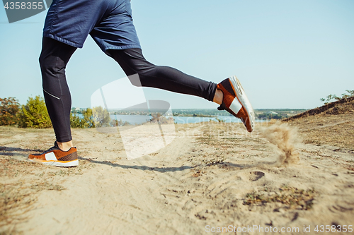 Image of Running sport. Man runner sprinting outdoor in scenic nature. Fit muscular male athlete training trail running for marathon run.