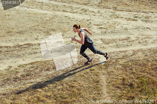 Image of Running sport. Man runner sprinting outdoor in scenic nature. Fit muscular male athlete training trail running for marathon run.