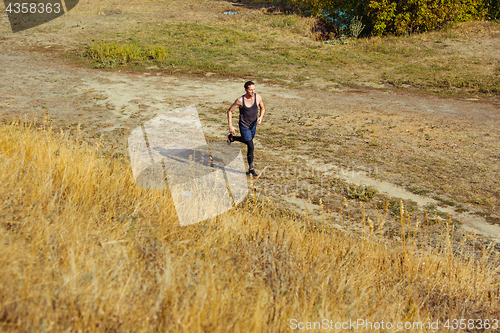 Image of Running sport. Man runner sprinting outdoor in scenic nature. Fit muscular male athlete training trail running for marathon run.