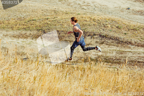 Image of Running sport. Man runner sprinting outdoor in scenic nature. Fit muscular male athlete training trail running for marathon run.