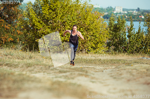 Image of Running sport. Man runner sprinting outdoor in scenic nature. Fit muscular male athlete training trail running for marathon run.