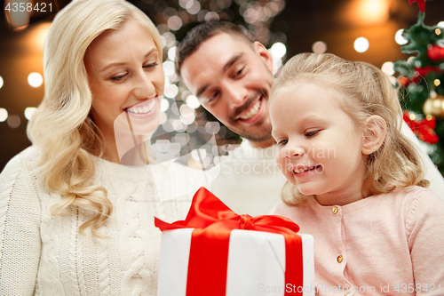 Image of happy family at home with christmas gift box