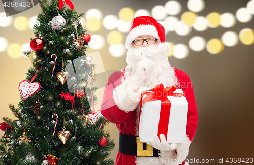 Image of santa claus with gift box at christmas tree