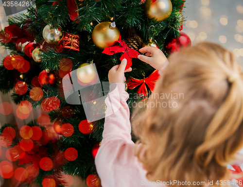 Image of close up of little girl decorating christmas tree
