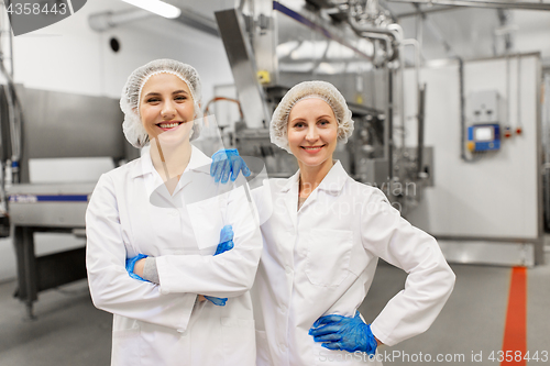 Image of happy women technologists at ice cream factory